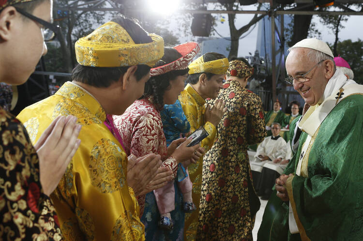 Pope Francis greets a family during the closing Mass of the World Meeting of Families on Benjamin Franklin Parkway in Philadelphia Sept. 27. (CNS photo/Paul Haring).