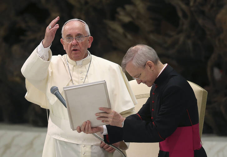 Pope Francis gives a blessing to the crowd during his weekly audience in Paul VI hall at the Vatican on Aug. 20. (CNS photo/Alessandro Bianchi, Reuters) 