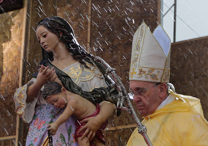 The rain falls as Pope Francis celebrates Mass adjacent to the airport in Tacloban, Philippines, in January. (CNS photo/Malacanang photo bureau handout via EPA)