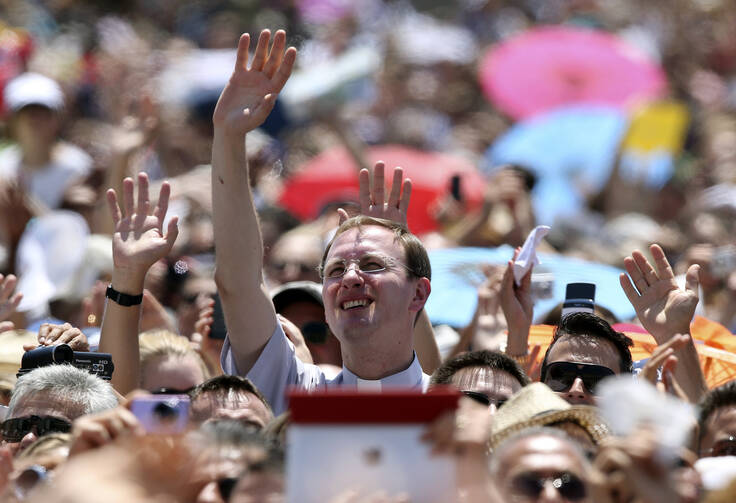 Clergyman waves as Pope Francis leads Angelus at Vatican.