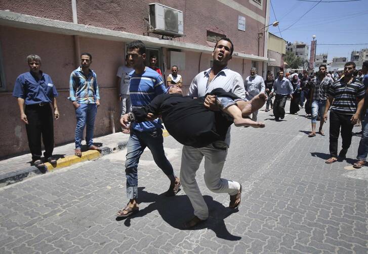 A Palestinian man rushes wounded woman into hospital in southern Gaza Strip.