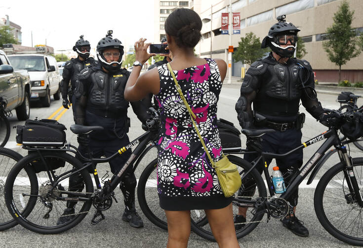 A demonstrator takes a picture of the police line during the Shut Down Trump & the RNC protest on July 17, in Cleveland. (AP Photo/John Minchillo)