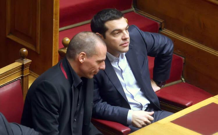 Prime Minister Alexis Tsipras, right, talks with Finance Minister Yanis Varoufakis at the Greek Parliament, Feb. 18.