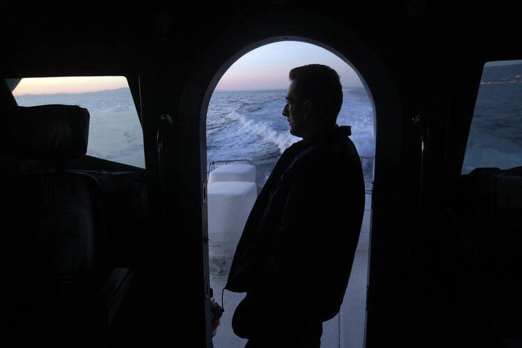 A sailor from the Greek Coast Guard monitors the Mediterranean Sea for undocumented migrants Sept. 24, 2014. (CNS photo/Orestis Panagiotou, EPA)