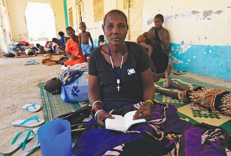 EXODUS. A woman fleeing an attack in South Sudan reads the Bible at a border gate in Joda, April 18, 2014. 