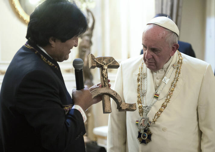 Bolivian President Evo Morales presents a gift to Pope Francis at the government palace in La Paz, Bolivia, July 8. The gift was a wooden hammer and sickle -- the symbol of communism -- with a figure of a crucified Christ. (CNS photo/L'Osservatore Romano)