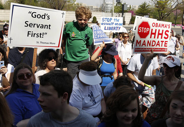 People hold signs during 2012 rally outside Department of Health and Human Services in Washington, D.C. (CNS photo/Bob Roller)