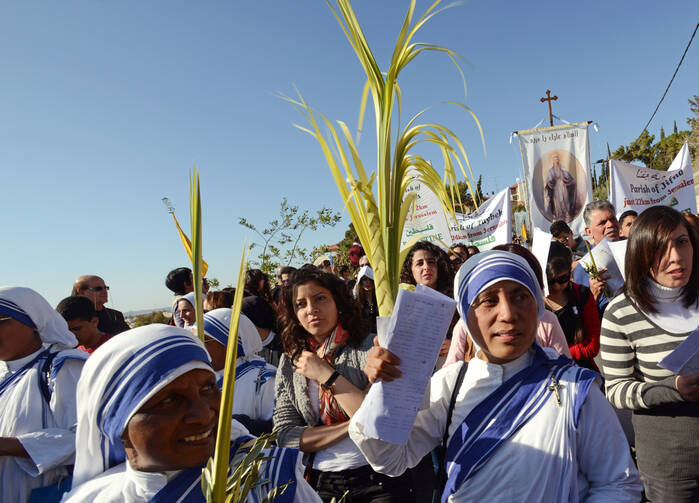 Pilgrims carry palm and olive branches during the Palm Sunday procession last year on the Mount of Olives last year.
