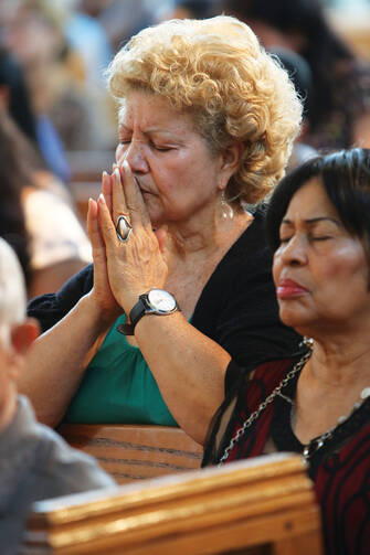 MAKING ALL WELCOME. A woman prays during a Spanish-language Mass at St. John-Visitation Church in the Bronx, N.Y., on Sept. 13. 