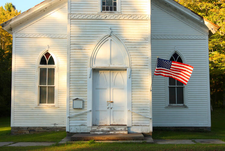 White country church and U.S. flag (iStock)