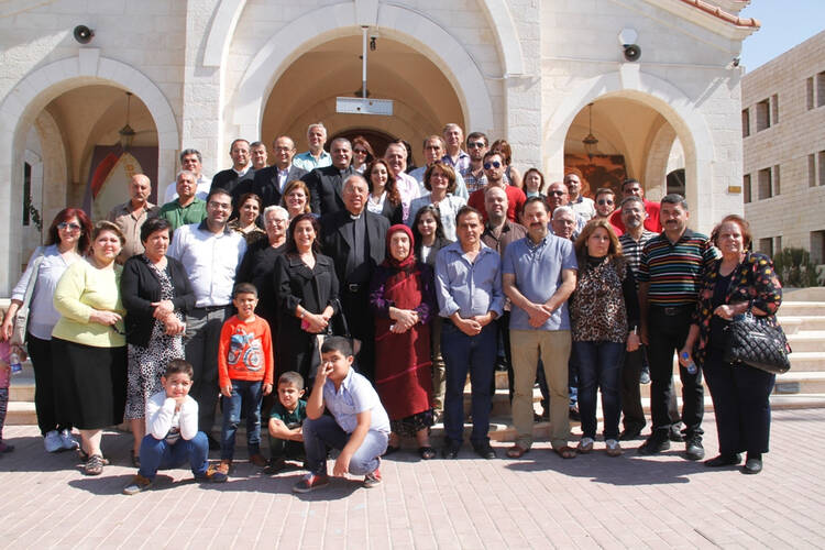 Iraqi refugees pose with speakers from Jordanian Catholic and Muslim institutions coming to their aid in Jordan.