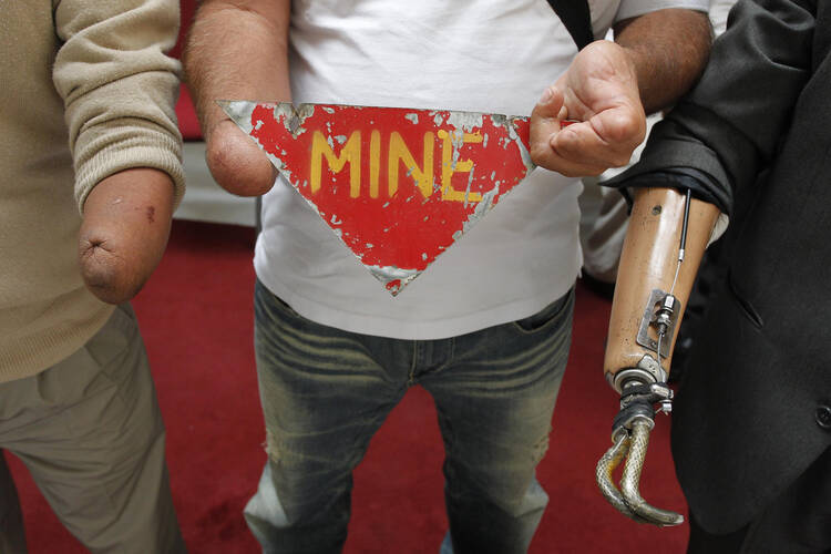 Land mine victims hold up a sign to support a global land mine ban in 2012.
