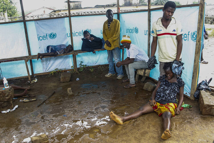 ATTENTION MUST BE PAID. Liberians wait outside the John F. Kennedy Ebola treatment center in Monrovia, Liberia, Sept. 18. 