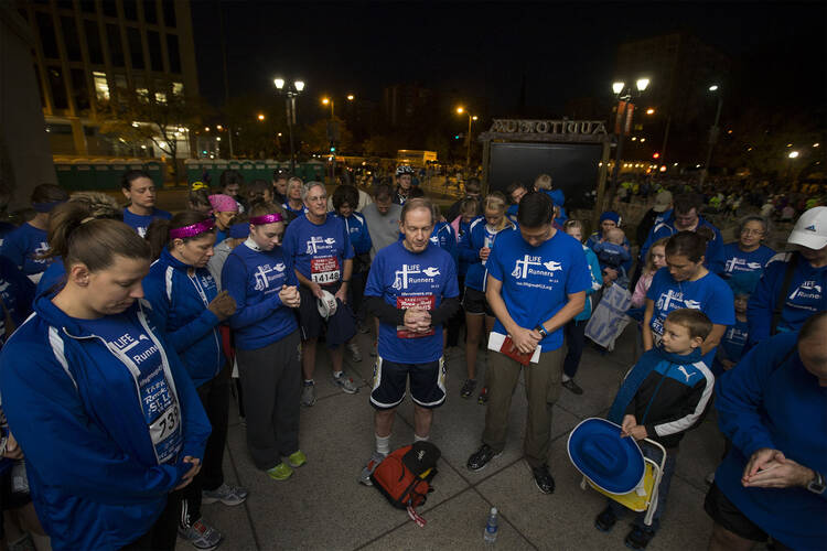  Download Files: Hi-res Image Web Image Bishop Paprocki prays with Life Runners before 2012 marathon in St. Louis