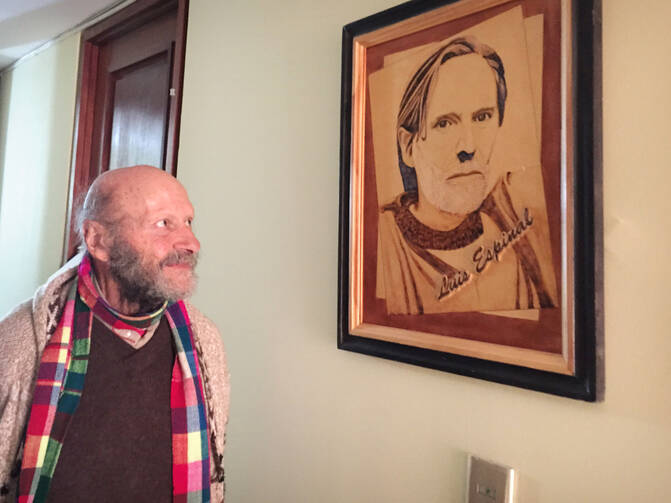 Jesuit Father Xavier Albo stands next to picture of slain Jesuit Father Luis Espinal in La Paz, Bolivia, July 3. On July 8, Pope Francis is expected to pray near the site where Father Espinal's remains were found in 1980. (CNS photo/David Agren) 