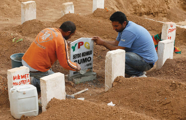 ￼FINAL REST. Men place a headstone at the grave of Seydo Mehmud Cumo, 44, at a cemetery in Suruc, Turkey, Oct. 11. Cumo was a Syrian Kurdish fighter killed in clashes with Islamic State militants in Kobani, Syria.