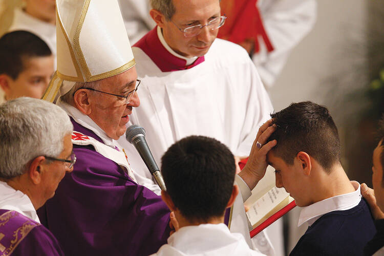 ￼A HOLY FATHER’S BLESSING. Pope Francis administers confirmation during Mass at the Parish of San Cirillo Alessandrino in Rome on Dec. 1.