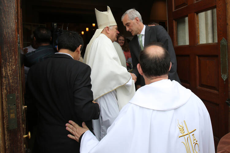 Miami Archbishop Thomas G. Wenski greets Denis McDonough, White House chief of staff, after celebrating the "Mission for Migrants" Mass May 29 at St. Peter's Catholic Church on Capitol Hill in Washington.