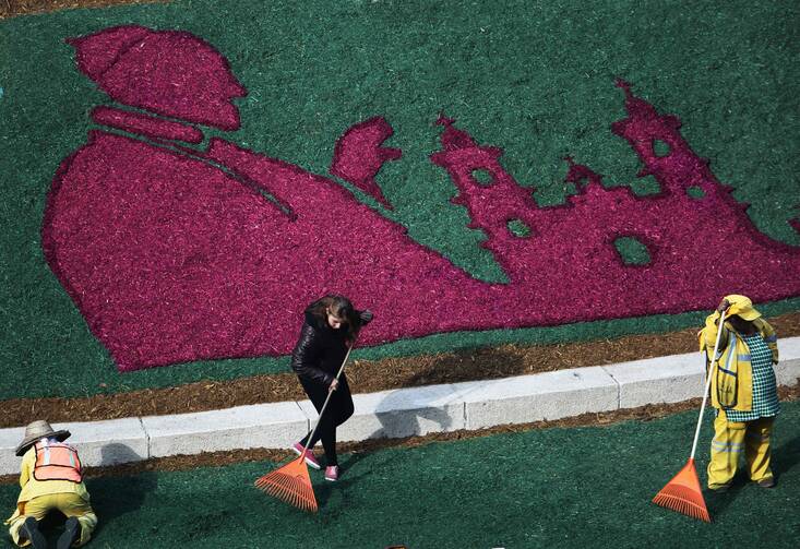 Workers put the finishing touches on an image of Pope Francis made out of flowers, on the lawn surrounding the Angel of Independence Monument in Mexico City, Wednesday, Feb. 10, 2016. Pope Francis travels to Mexico Feb. 12-18. (AP Photo/Enric Marti)