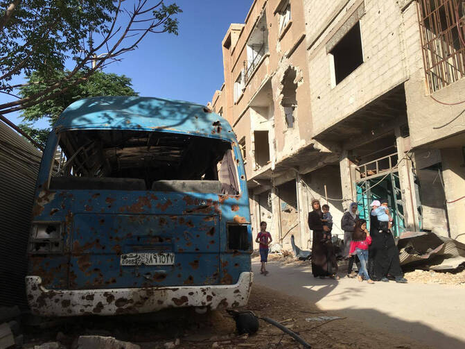 This image released by the International Committee for the Red Cross shows civilians in Daraya, Syria on Wednesday, June 1, 2016. A besieged suburb of Syria's capital received humanitarian aid Wednesday for the first time since 2012, as the United Nations. The International Committee for the Red Cross (ICRC) reported that a joint convoy with the U.N. and the Syrian Arab Red Crescent entered the Damascus suburb of Daraya in the afternoon.