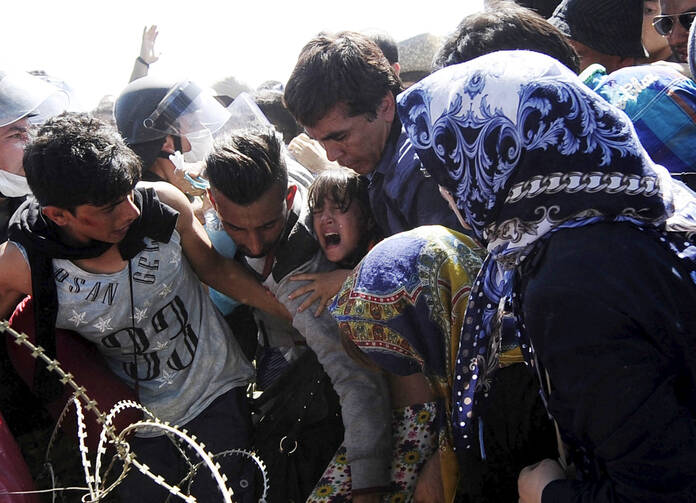 A young girl screams as migrants rush to cross into Macedonia at the Macedonian-Greek border, Sept. 2 (CNS/Ognen Teofilovski, Reuters).