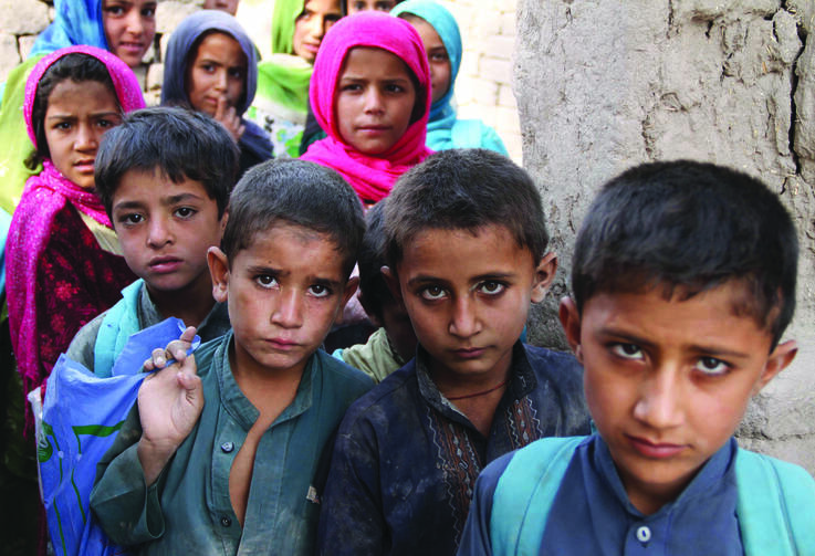 GETTING TO CLASS. Afghan children arrive at a school near a refugee camp near Kabul.