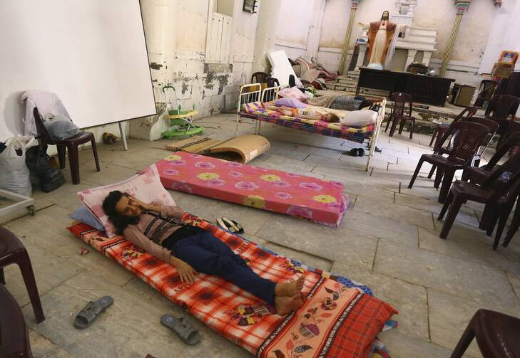 An Iraqi Christian family fleeing the violence in Mosul sleeps inside Sacred Heart of Jesus Chaldean Church in Telkaif, Iraq, Mosul July 20. Pope Francis called for prayers, dialogue, and peace, as the last Iraqi Christians flee Mosul. 