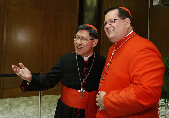 Cardinals Luis Tagle of Manila, Philippines, and Gerald Lacroix of Quebec exchange greetings.