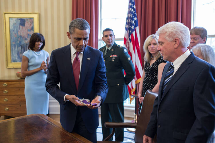 President Obama holds stole that belonged to Father Emil Kapaun.