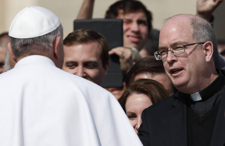 Pope Francis greets Father Robert W. Oliver, secretary of the Pontifical Commission for the Protection of Minors, during general audience in St. Peter's Square.