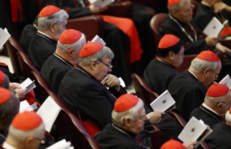 Australian Cardinal George Pell, prefect of the Vatican Secretariat for the Economy, center, participates in prayer at the start of a session of the Synod of Bishops on the family at the Vatican, Oct. 15 (CNS photo/Paul Haring).
