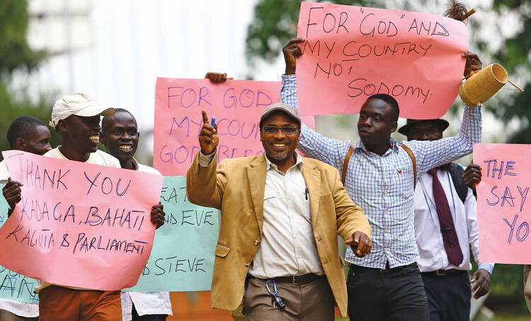 LAW MEN. Men in Kampala, Uganda, Feb. 24, celebrate a new anti-homosexuality law, which imposed a harsh punishment for homosexual acts. The law was struck down in August, but a similar new bill is being considered.