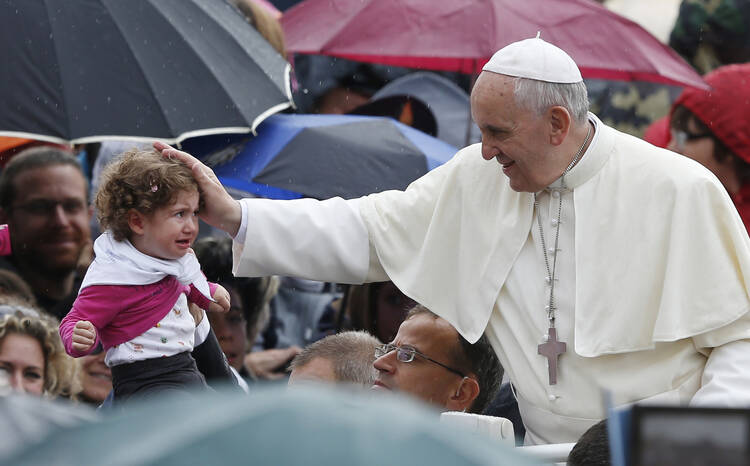 Pope greets a baby as he arrives to lead general audience in St. Peter's Square, Oct. 9