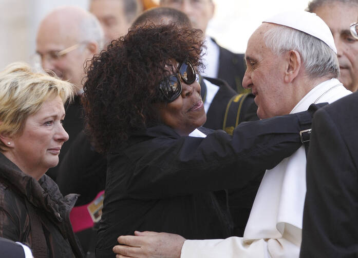 Patience Dodo of Gabon, who is blind, hugs Pope Francis as he leaves his general audience in St. Peter's Square at the Vatican, April 10, 2013.