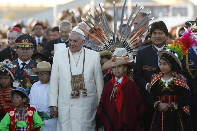 Pope Francis walks with Bolivian President Evo Morales and children in traditional dress as he arrives at El Alto International Airport in La Paz, Bolivia, July 8 (CNS photo/Paul Haring).