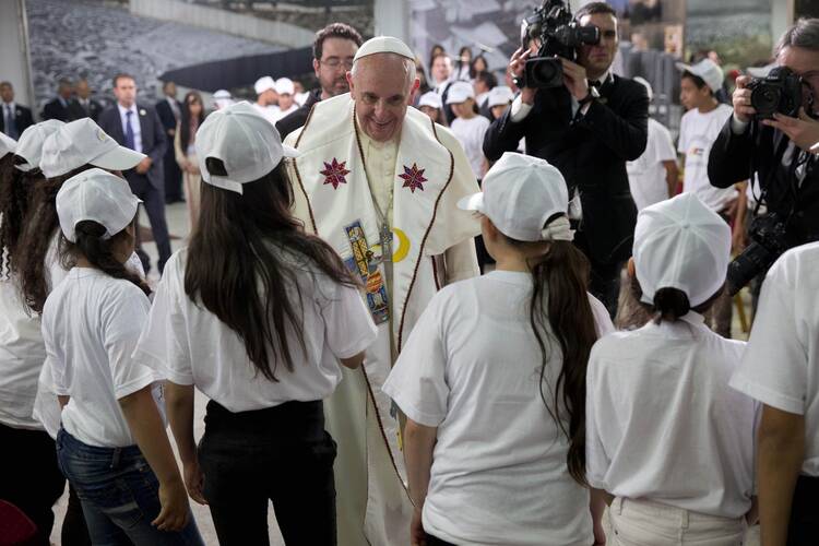 Pope Francis is greeted by young people at the Dehiyshe Refugee Camp's Phoenix Cultural Center, near Bethlehem, on the occupied West Bank.