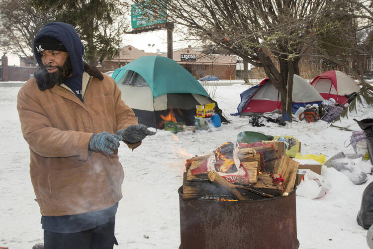 Charles "C.J." Jones warms himself by a fire Jan. 9 in a tent city that homeless people have established near downtown Detroit.