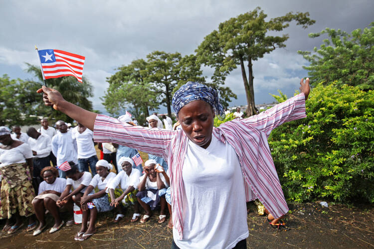 A Liberian woman prays for the end of Ebola outside Monrovia, Liberia, last October.