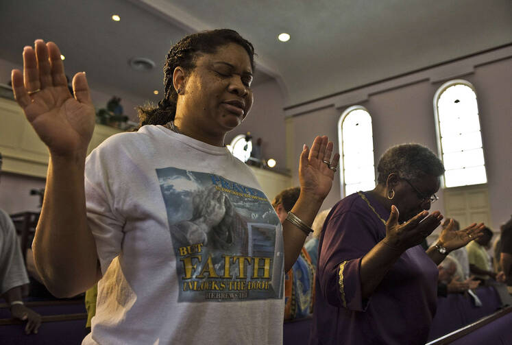 Women pray during service after George Zimmerman murder trial in Florida, July 13.