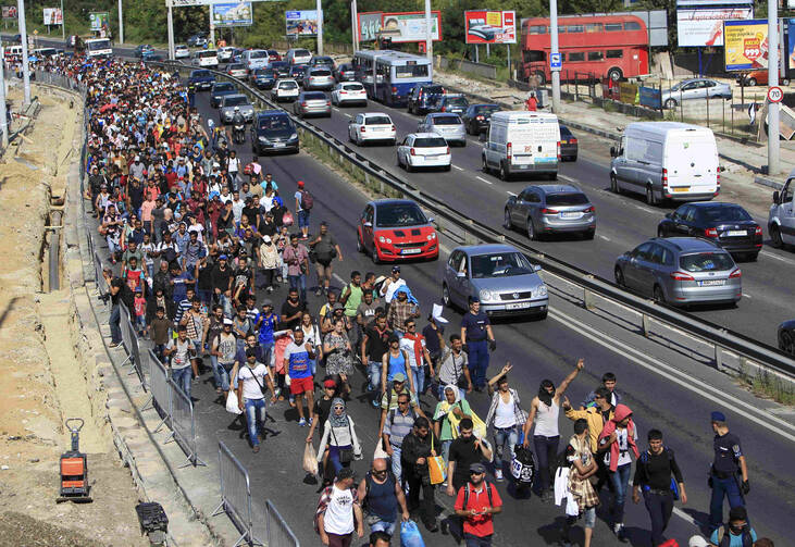 Migrants walk along a highway in Bicske, Hungary, near the border with Austria Sept. 4. (CNS/Bernadett Szabo, Reuters) 