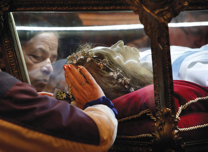 MYSTICAL ENCOUNTER. Worshippers venerate the relics of St. Maria Goretti at St. John Cantius Church in Chicago.