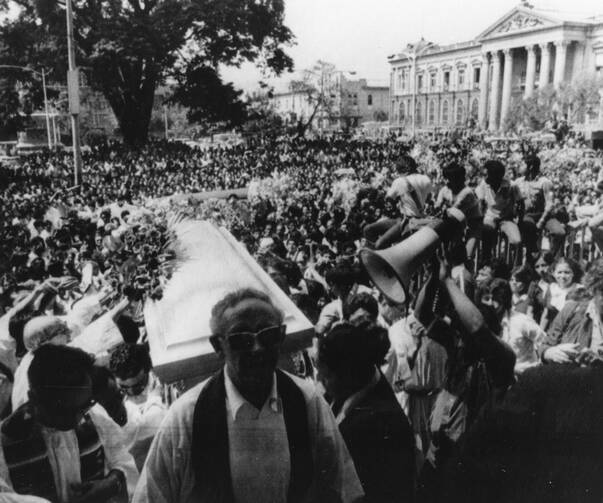 Thousands gather outside the Metropolitan Cathedral in San Salvador March 30, 1980, as the casket of slain Archbishop Oscar Romero is carried inside for a funeral Mass.