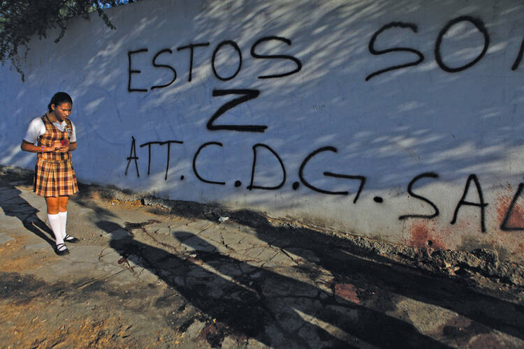 Return on Investment: A girl looks at blood stains and graffiti left by gunmen at the scene of a triple homicide in Monterrey, Mexico, in June 2011.