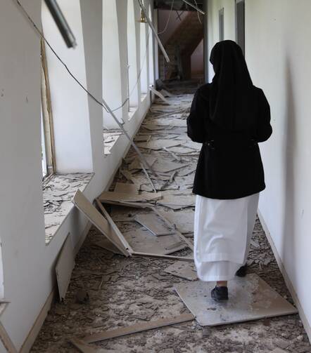 A nun walks through the hallway of the badly damaged convent of the Dominican Sisters of St. Catherine of Siena in Qaraqosh, Iraq. (CNS photo/courtesy John E. Kozar, CNEWA)