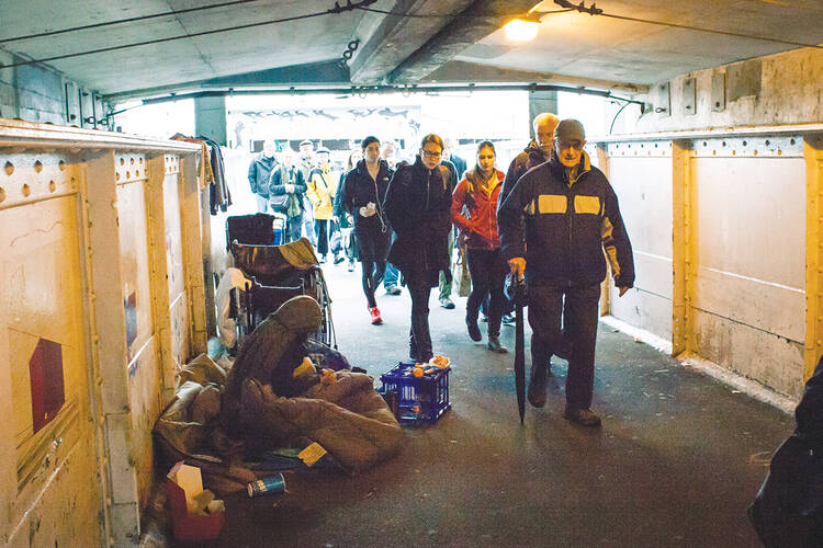 ￼SHELTER THE HOMELESS. Commuters walk past a woman resting in a public walkway near a ferry terminal in Seattle, Wash., in January.