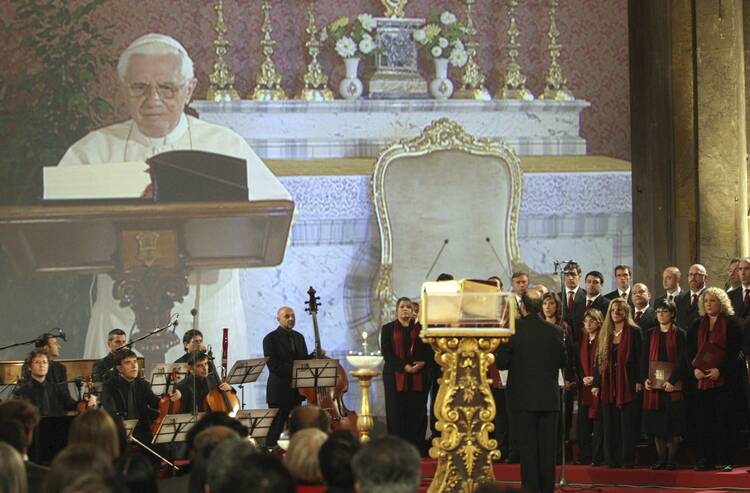 Pope Benedict XVI is shown reading the Bible in a live television feed projected inside the Basilica of the Holy Cross in Rome Oct. 5, 2008 (CNS photo/Alessandro De Meo, Reuters).