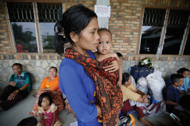 REFUGE. A Christian mother and child on Oct. 15 at a camp for displaced people at a Catholic school in Manduamas, Indonesia. More than 4,000 Aceh residents fled to North Sumatra following attacks by Islamic groups and the burning of two churches.
