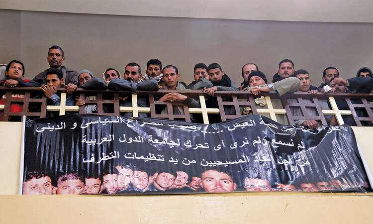 ￼SEE THE VICTIMS. Neighbors and friends of 21 Coptic Christians executed in Libya attend Mass at a church south of Cairo Feb. 16.