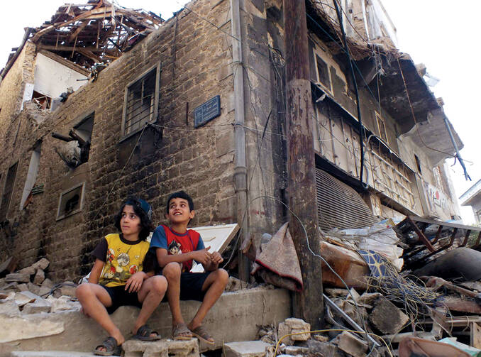 Their City in Ruins: Children sit among rubble in a besieged neighborhood in Homs, Syria, on Sept. 19