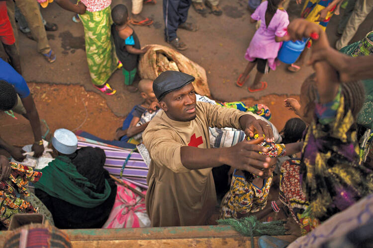 LIFE SAVER. Father Bernard Kenvi helps a Muslim child fleeing violence climb down from a truck in Bossemptele, in Central African Republic, on March 8.